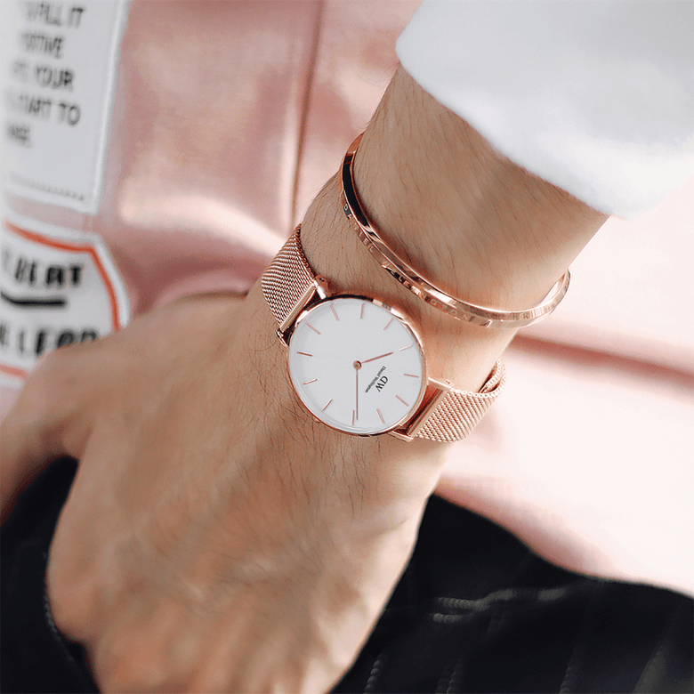 Classic Bracelet Rose Gold by Daniel Wellington worn on the wrist with a matching rose gold mesh watch, showcasing its slim, adjustable cuff design and understated elegance suitable for everyday wear.