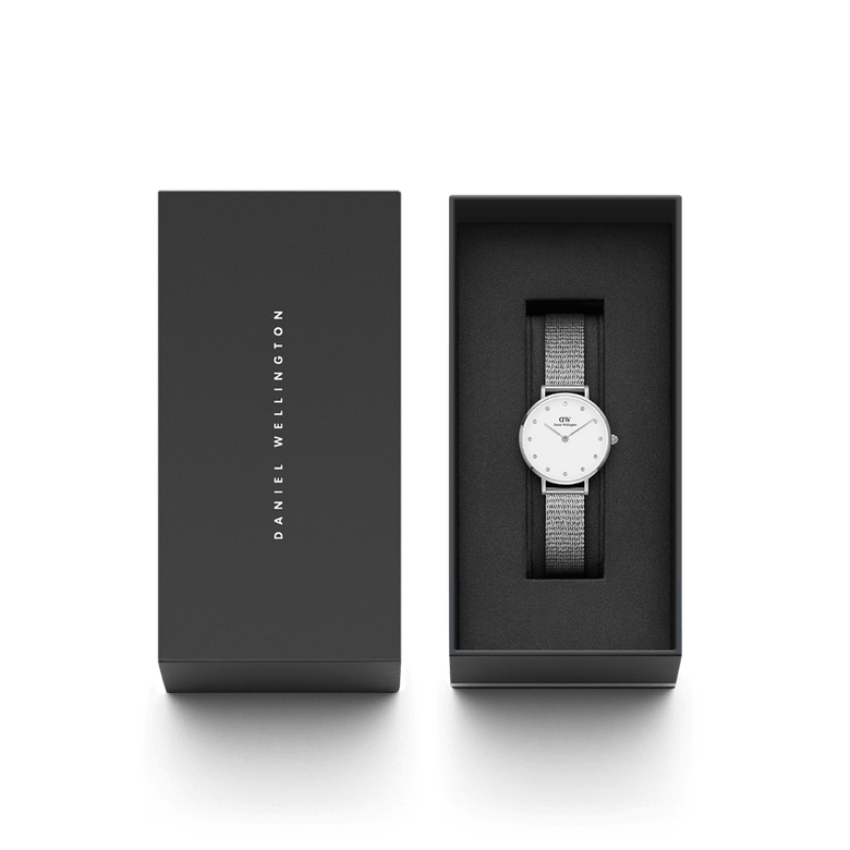 Petite Lumine Pressed Sterling presented in its sleek black Daniel Wellington gift box, featuring a silver mesh strap and minimalist eggshell white dial with crystal markers, ideal for gifting or personal use.