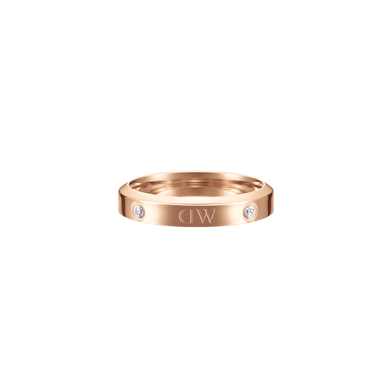 Classic Lumine Ring Rose Gold features a slim rose gold band with a polished finish, alternating crystal stones and logo etchings, offering a minimalist and elegant look suitable for everyday wear or gifting.