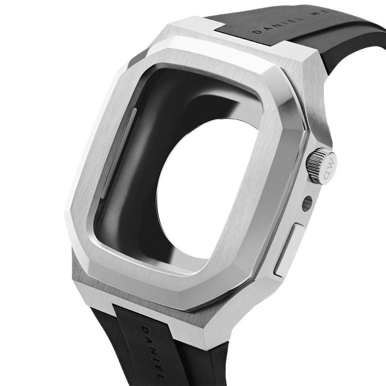 Switch Silver Apple Watch case in brushed stainless steel with an octagonal geometric frame, shown from a side angle with a black rubber strap and ergonomic design for easy installation.