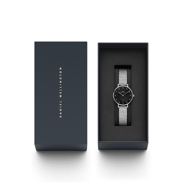 Petite Lumine Pressed Piano Black MoP Silver watch with a black mother of pearl dial and silver mesh-inspired strap, elegantly presented in a Daniel Wellington gift box.