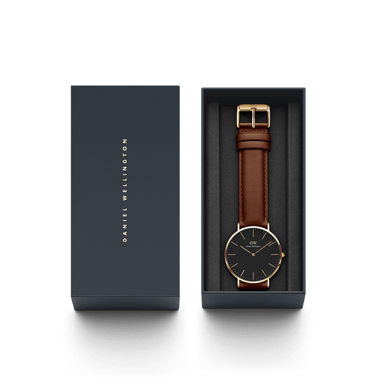 Classic St Mawes Gold watch with a black dial, gold case, and brown leather strap, presented in a branded Daniel Wellington gift box.