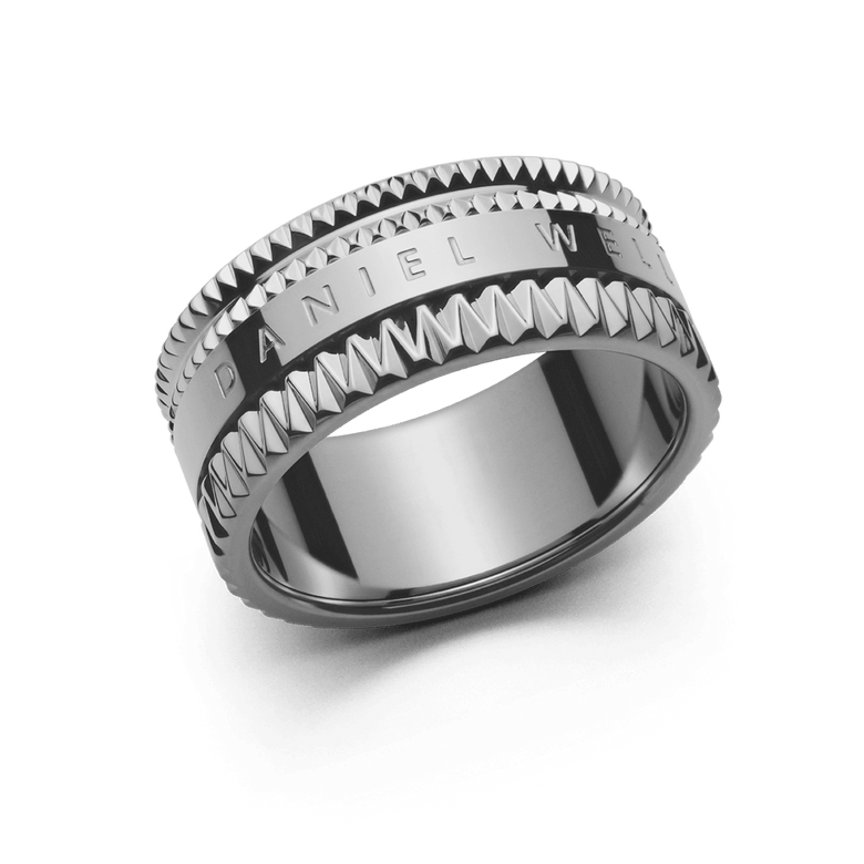 Wide silver ring with geometric textured edges and a polished centre engraved with the Daniel Wellington logo, showcasing a modern, architectural design.