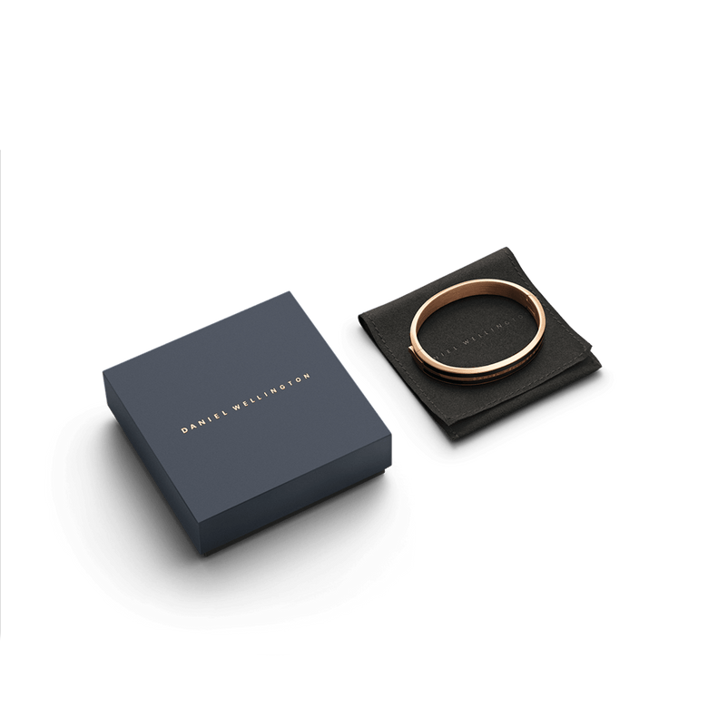 Emalie Infinite Rose Gold Black bracelet displayed on a black pouch next to a navy Daniel Wellington gift box, highlighting its elegant packaging and polished rose gold and black enamel design.