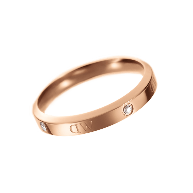 Classic Lumine Ring Rose Gold displays a slim, polished rose gold band with alternating crystal stones and logo etchings, designed for understated elegance and versatile styling.