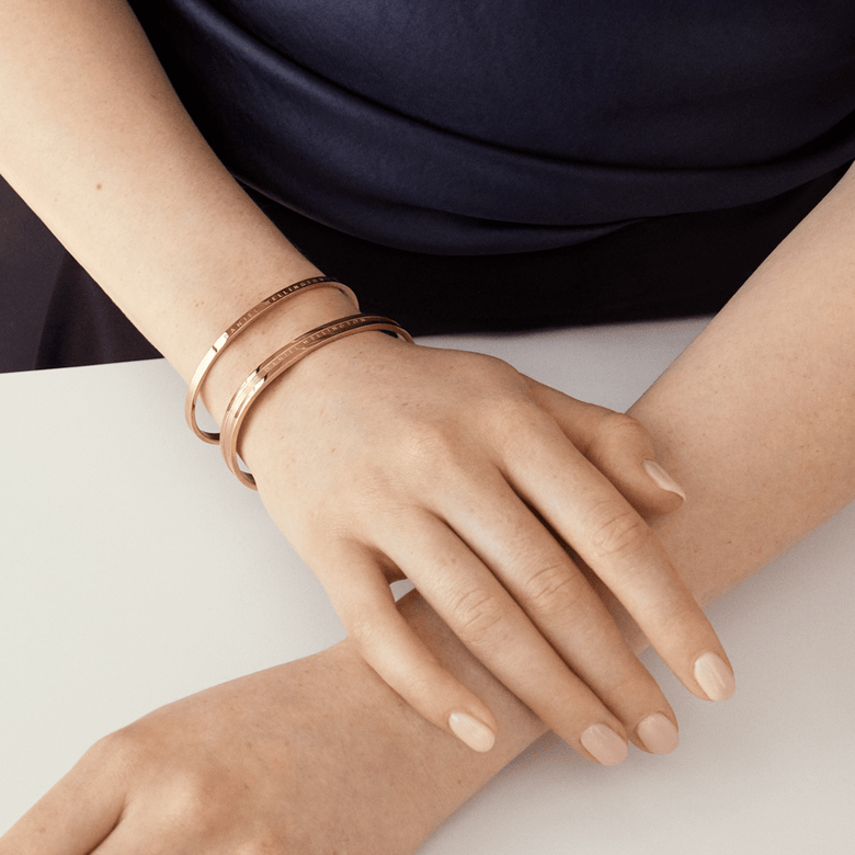 Elan Bracelet Rose Gold worn on a wrist and styled with a second matching bracelet, highlighting its polished finish and minimalist cuff design for a modern, elegant look.