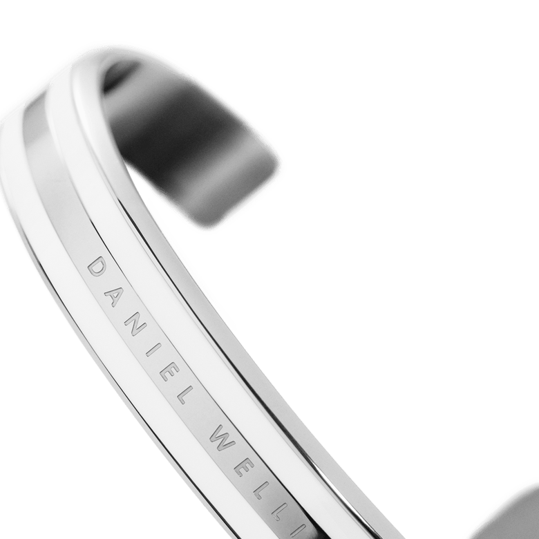 Close-up of the Emalie Bracelet Silver showing the polished silver finish, satin white enamel detail, and Daniel Wellington branding engraved along the minimalist cuff.