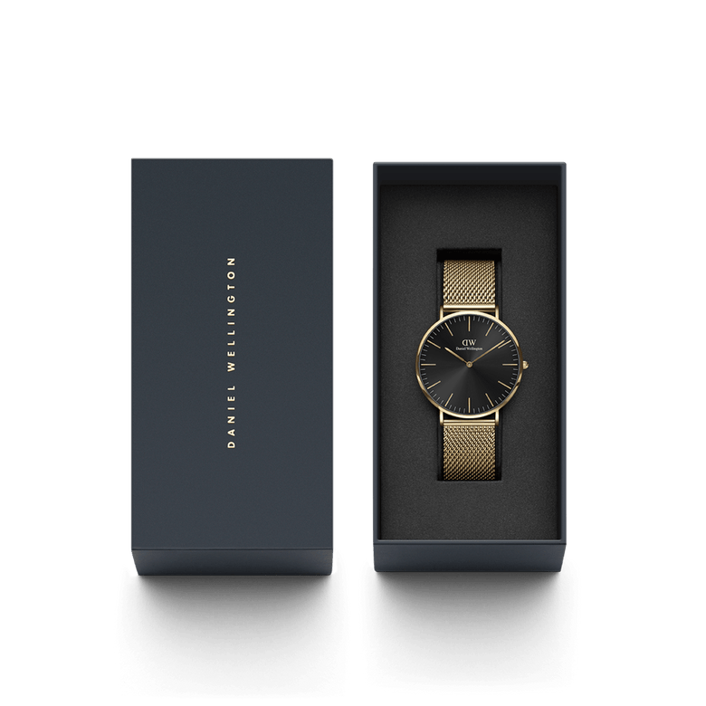 Classic Mesh Onyx Gold watch with a black sunray dial and gold mesh strap, elegantly presented in a dark gift box with Daniel Wellington branding, ideal for gifting or special occasions.