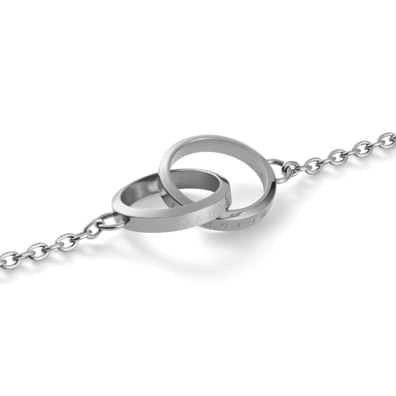 Close-up of the Elan Unity Necklace Silver pendant, showing two polished interlocked rings engraved with subtle branding on a fine silver chain.