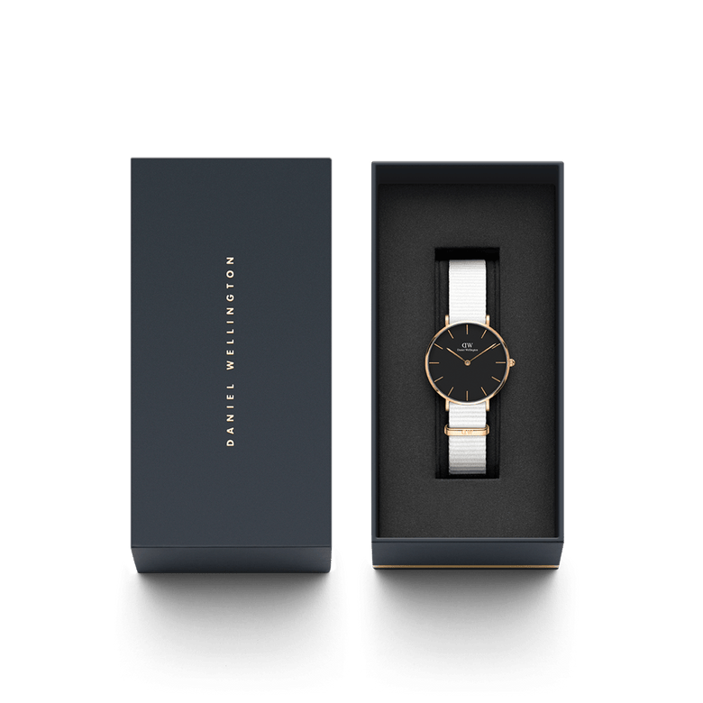 Petite Dover Black Rose Gold ladies watch with a rose gold case, minimalist black dial, and white NATO strap, presented in a sleek Daniel Wellington gift box.
