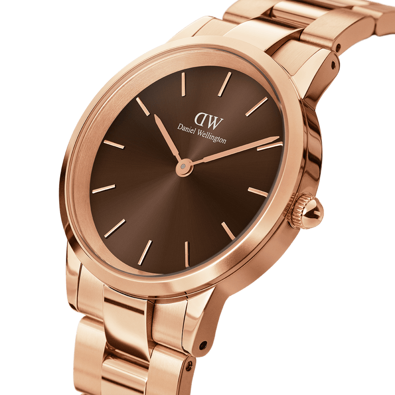 Close-up of the Daniel Wellington Iconic Link Amber watch, showing the sunray brown dial, rose gold stainless steel case, and polished bracelet with minimalist detailing.