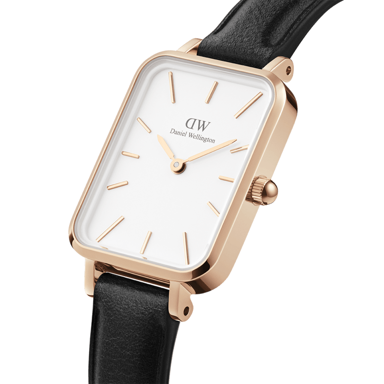 Close-up of the Quadro Pressed Sheffield Rose Gold watch showing its rectangular white dial, rose gold case, minimalist hour markers, and slim black leather strap.