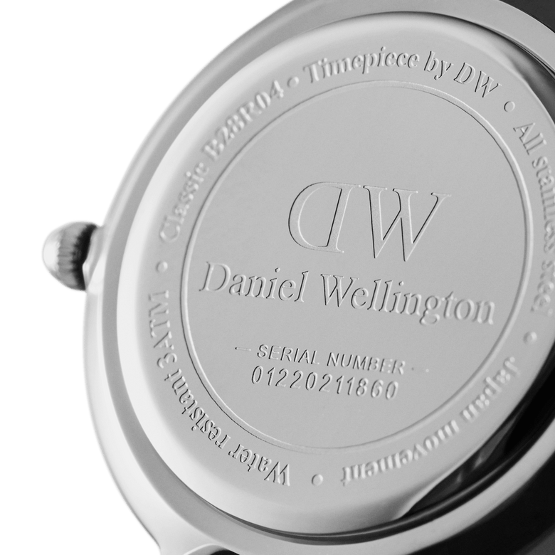 Close-up of the Petite Cornwall Silver watch case back, showing Daniel Wellington branding, engraved serial number, and stainless steel finish.